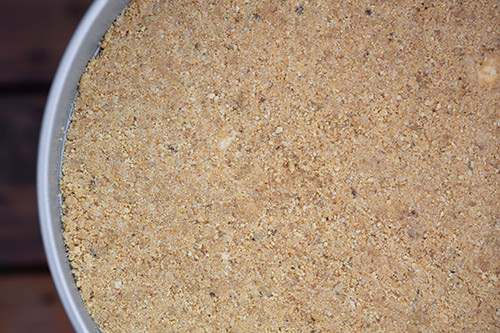 Graham cracker crust pressed into spring form pan for Pumpkin Cheesecake